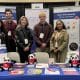 A group of 4 students from Penn State University stand with an AMSBIO employee at their stand at a conference