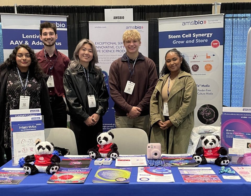 A group of 4 students from Penn State University stand with an AMSBIO employee at their stand at a conference